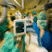 Medical professionals in surgical attire working in an operating room setting.